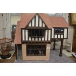 A half-timber framed dolls house with electricity and some furniture and accessories