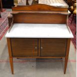An Edwardian mahogany washstand with galleried marble top over a pair of cupboard doors, raised on