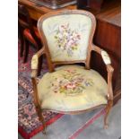 A French carved walnut fauteuil/armchair with floral tapestry upholstery