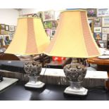 A pair of silvered open-work table lamps with maize coloured woven shades