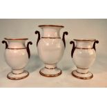 A 19th century garniture set of three vases raised on circular pedestal bases with bronze lustre