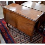 A 19th century mahogany drop leaf dining table raised on turned supports with castors