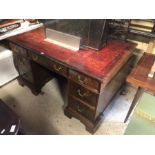 A late 19th/20th century mahogany twin pedestal desk with inset leather top over nine drawers