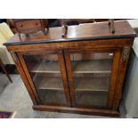 A Victorian inlaid walnut and gilt metal mounted bookcase, the pair of glazed doors enclosing two