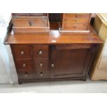 A modern hardwood cabinet with six small drawers next to a panelled cupboard door