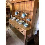 A Victorian stripped pine high dresser, three drawers over an open potboard base