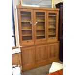 A bespoke two section light oak library bookcase, three glazed doors enclosing adjustable shelves