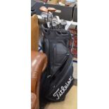 A Titleist golf bag containing three taylormade woods, nine wilson irons and a putter