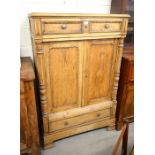 A French waxed pine hall cupboard with two drawers over panelled doors and a single long drawer