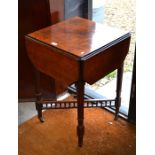 An Edwardian mahogany drop leaf card table with folding counter wells raised on fluted square