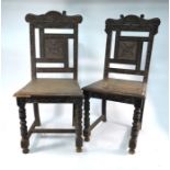 A pair of Victorian carved oak hall chairs