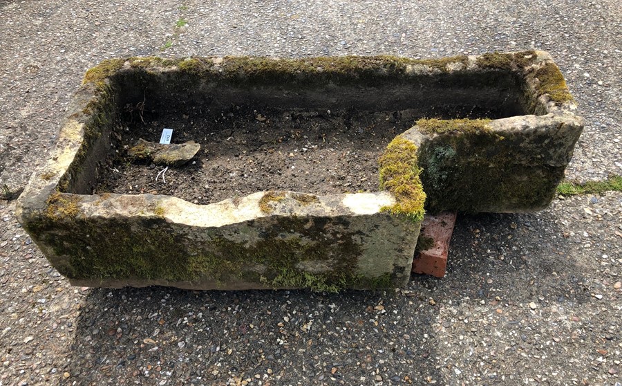 An antique weathered cut stone sink/planter,