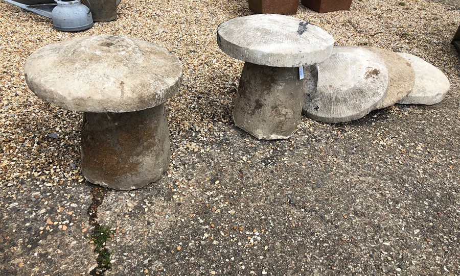A pair of weathered antique hand cut Hampshire stone staddle stones and caps
