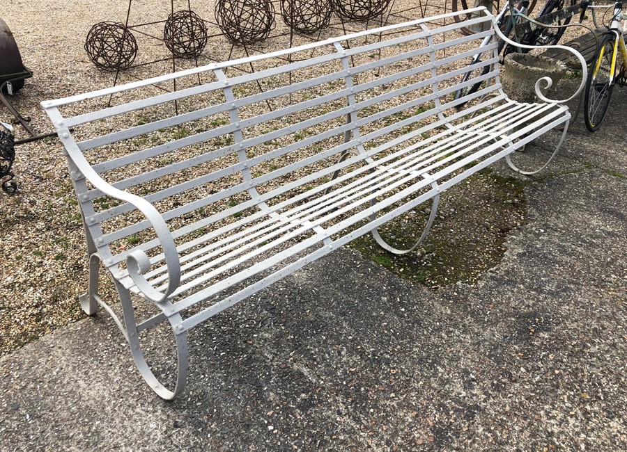 A painted antique wrought iron slatted four seater garden bench