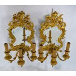 A pair of good quality gilt ormolu mirror backed twin arm wall sconces