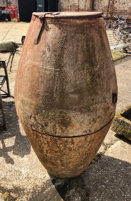 A large old steel olive oil barrel