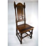 A 17th century oak arched panel back chair