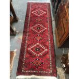 A Persian Hamadan red ground diamond lozenge design rug