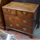 A Georgian oak chest of two short over two long graduated drawers