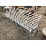 A painted antique wrought iron slatted four seat garden bench