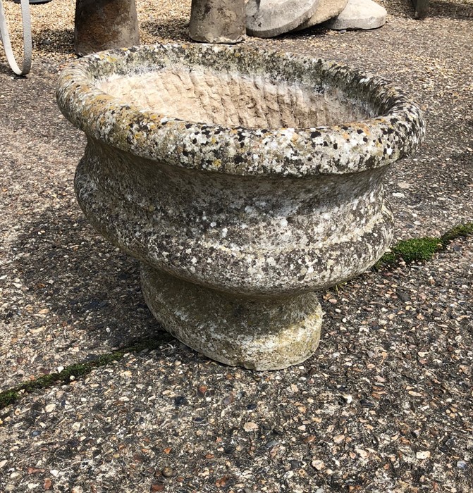 A weathered antique cut stone urn planter