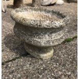 A weathered antique cut stone urn planter
