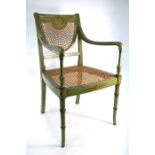 An antique pale green and polychrome decorated caned seat open armchair