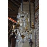 A vintage gilt metal framed crystal strung four branch chandelier