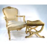 An antique continental patinated gilt and cream framed salon armchair