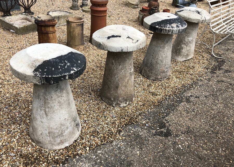 A set of four circular tapering Hampshire stone staddlestones and caps