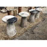 A set of four circular tapering Hampshire stone staddlestones and caps