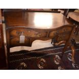 A mahogany cross banded serpentine front  dressing table with four drawers, raised on square