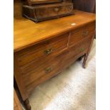An Edwardian dressing chest with three drawers raised on turned supports and castors