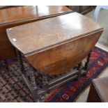 Oak drop leaf table with end drawer and carved frieze raised on gateleg action turned supports