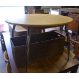 A modern beech extending dining table with storable butterfly action central leaf and tubular