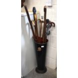 A Regency style metal stick stand containing nine assorted walking sticks to include examples with
