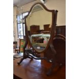 A strung mahogany shield-shaped swing mirror