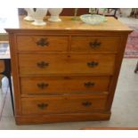 A light ash chest of two short over three long drawers with brass handles, raised on a plinth base