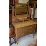 An Arts & Crafts style oak dressing table, the raised back with bevelled mirror and small central