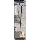 An antique stone mounted wrought iron boot scraper