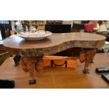 A heavy hardwood cross section coffee coffee table raised on four carved elephant head supports