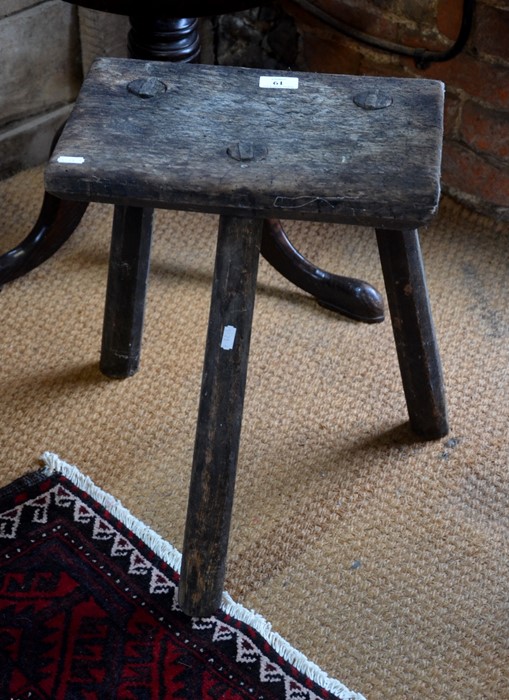 An antique jointed milking stool on octagonal tripod supports
