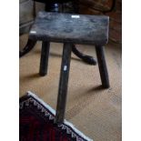 An antique jointed milking stool on octagonal tripod supports