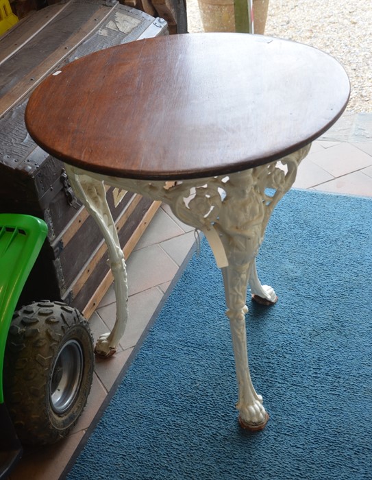 A painted cast iron terrace table with stained circular teak top