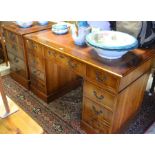 A reproduction yew wood twin pedestal desk with gilt tooled tan leather top over eight drawers to/
