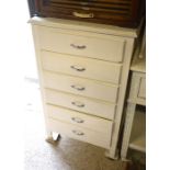 A white-painted six drawer tall-boy chest