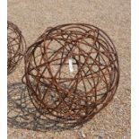 A large armillary garden-art feature with spherical weathered metal framework