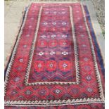 A Persian Balouch rug with repeating floral motifs on navy ground within repeating border 223 x