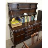 An Ercol dark elm Old Colonial style dresser with a two shelf plate rack over four central drawers