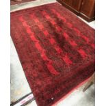 An old Afghan carpet, the black gul design on dull red ground